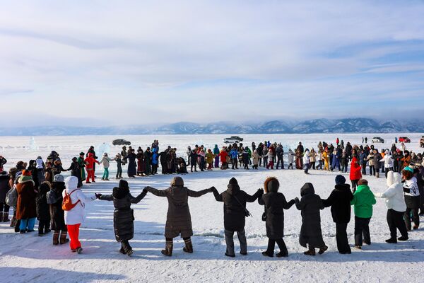 Посетители на фестивале ледовых скульптур Olkhon Ice Park, проходящем на береговой линии озера Байкал на острове Ольхон