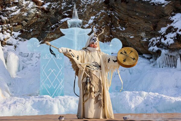 Девушка в национальном костюме выступает на фестивале ледовых скульптур Olkhon Ice Park, проходящем на береговой линии озера Байкал на острове Ольхон
