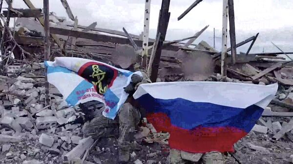 Российские военнослужащие разворачивают флаг России в селе Крынки. Кадр видео
