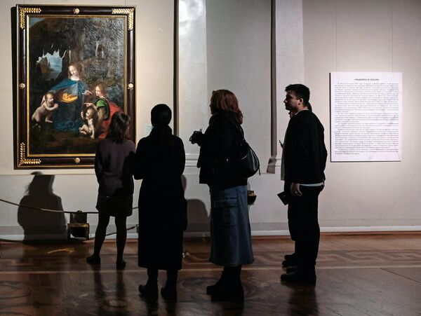 Посетители возле картины Мадонна в скалах в на открытии выставки Новые загадки картин Леонардо да Винчи в Государственном Эрмитаже