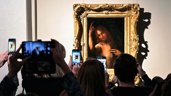 Посетители фотографируют картину Ангел на открытии выставки Новые загадки картин Леонардо да Винчи в Государственном Эрмитаже