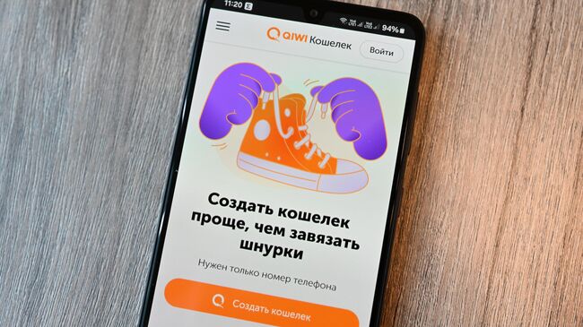 Страница сайта QIWI на экране смартфона