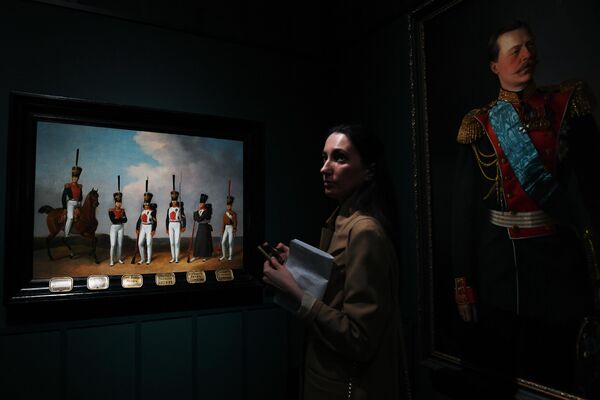 Посетительница знакомится с экспозицией на выставке Сокровища полковых музеев в Государственном историческом музее в Москве