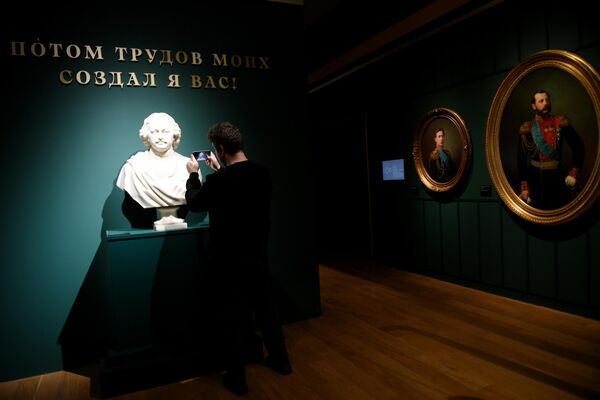 Посетитель фотографирует бюст императора Петра I на выставке Сокровища полковых музеев в Государственном историческом музее в Москве