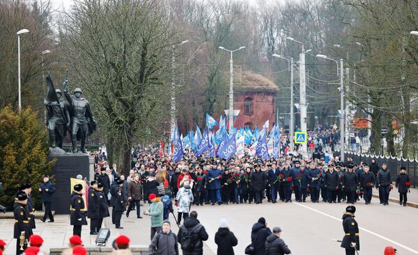 Горожане участвуют в шествии и возложению цветов к памятнику 1200 гвардейцам в Калининграде в честь празднования Дня защитника Отечества