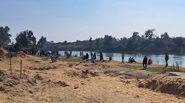 Родственники погибших рабочих ждут спасателей на берегу канала в провинции Гиза