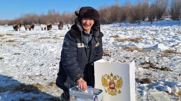 Мужчина принимает участие в досрочном голосовании на выборах президента России в Якутии