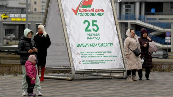 Горожане у агитационного предвыборного баннера в Единый день голосования на улице в Минске
