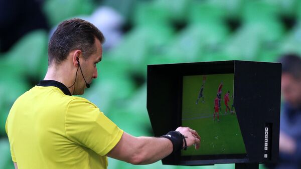 Главный арбитр встречи Евгений Турбин просматривает видеоповтор игрового момента в матче 20-го тура чемпионата России