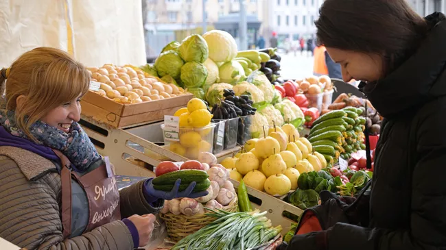 Продавец и покупательница на ярмарке выходного дня