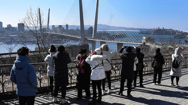 Китайские туристы на фоне Золотого моста во Владивостоке