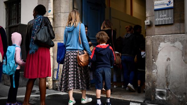Женщины ведут детей в школу в Париже