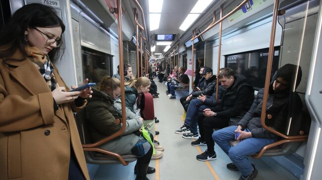 Пассажиры в вагоне поезда Большой кольцевой линии московского метрополитена