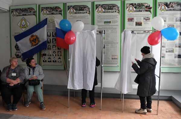 Избиратели и члены избирательной комиссии в ходе досрочного голосования на выборах президента РФ в поселке Аскания-Нова в Херсонской области
