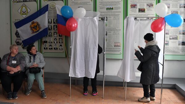 Избиратели и члены избирательной комиссии в ходе досрочного голосования на выборах президента РФ в поселке Аскания-Нова в Херсонской области