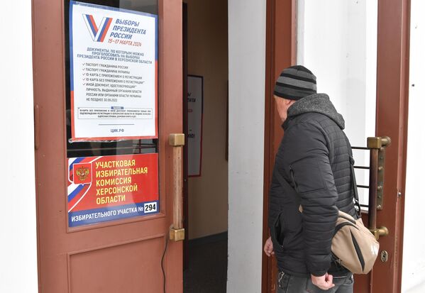 Мужчина заходит на избирательный участок №294 в ходе досрочного голосования на выборах президента РФ в поселке Аскания-Нова в Херсонской области