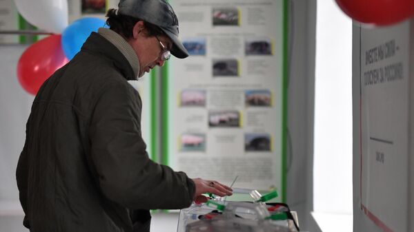 Мужчина голосует на избирательном участке № 294 в ходе досрочного голосования на выборах президента РФ в поселке Аскания-Нова в Херсонской области