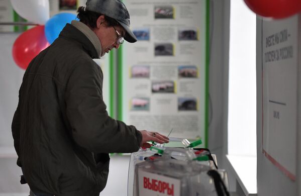Мужчина голосует на избирательном участке № 294 в ходе досрочного голосования на выборах президента РФ в поселке Аскания-Нова в Херсонской области