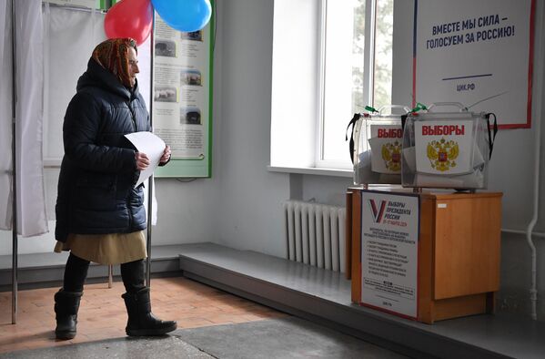 Женщина на избирательном участке № 294 в ходе досрочного голосования на выборах президента РФ в поселке Аскания-Нова в Херсонской области