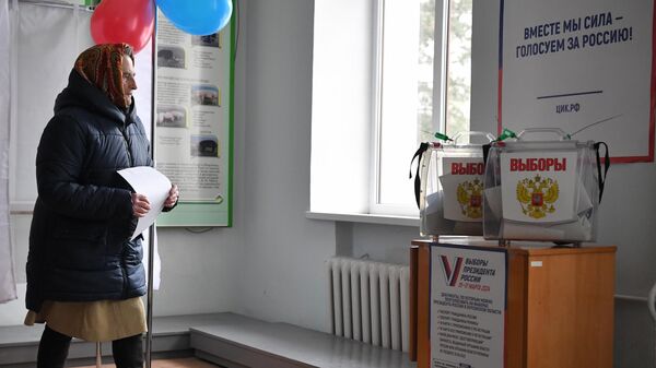 Женщина на избирательном участке № 294 в ходе досрочного голосования на выборах президента РФ в поселке Аскания-Нова в Херсонской области