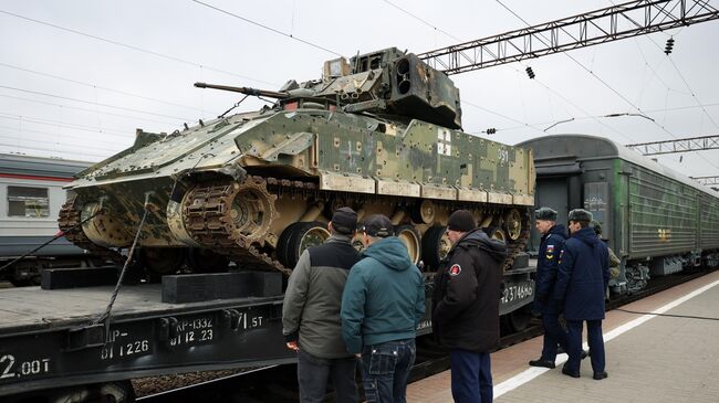 Посетители осматривают боевую машину пехоту М2 Брэдли ВСУ, захваченную Вооруженными силами РФ в ходе специальной военной операции на Авдеевском направлении