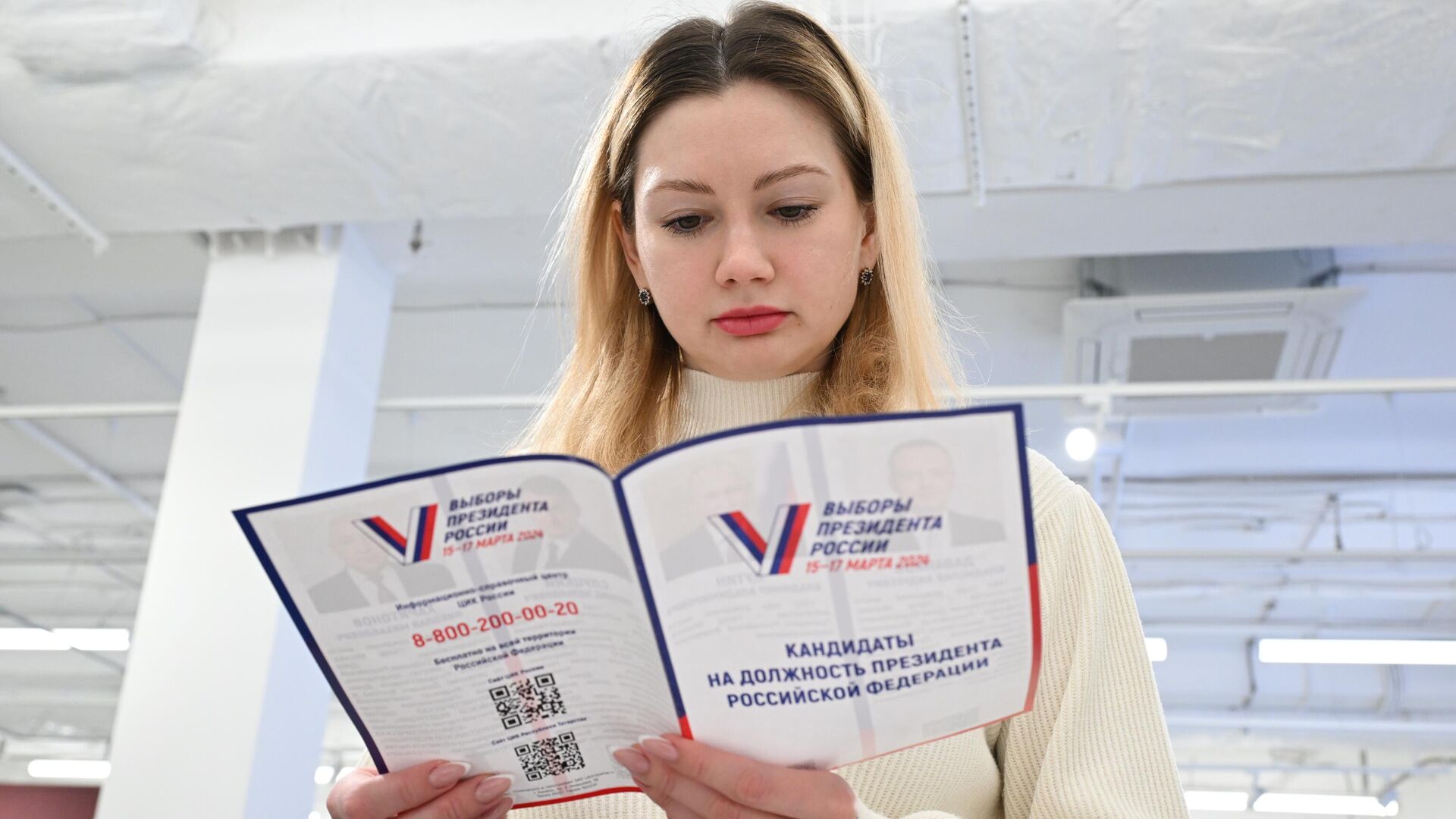 Девушка читает брошюру с информацией о кандидатах на должность президента России - РИА Новости, 1920, 05.03.2024