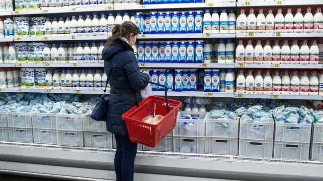 Покупатель у прилавка с молочной продукцией в магазине