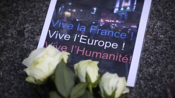 Плакат и цветы в память о жертвах терактов перед посольством Франции в Берлине