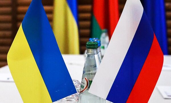 Флажки на столе, за которым проходили российско-украинские переговоры Флажки на столе, за которым проходили российско-украинские переговоры