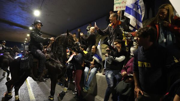 Конный отряд полиции Израиля разгоняет толпу антиправительственных активистов в Тель-Авиве. 9 марта 2024