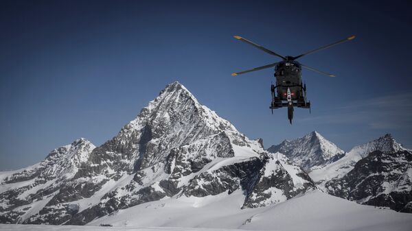 Вертолет ВВС Швейцарии, летящий над перевалом Тете-Бланш между Церматтом и Ароллой
