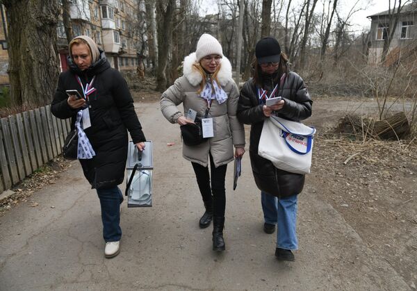 Члены избирательной комиссии на выездном голосовании в Донецке в первый день досрочного голосования на выборах президента РФ в Донецкой народной республике