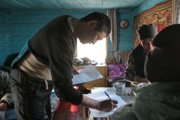 Мужчина голосует на выездном досрочном голосовании на выборах президента РФ на удаленной животноводческой стоянке чабанов в горах Кош-Агачского района Республики Алтай