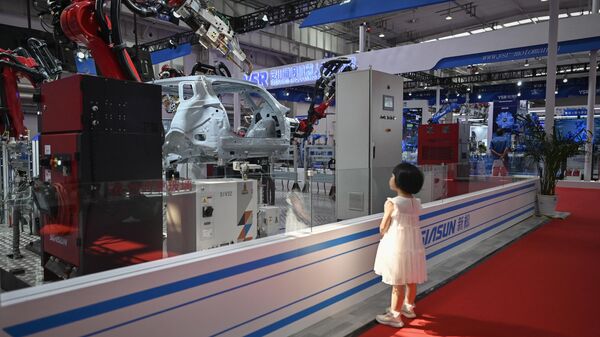 Девочка рассматривает модель на ежегодной конференции роботов в Пекине