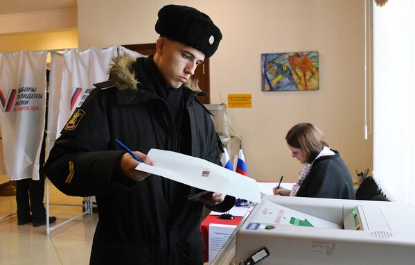 Военнослужащий Тихоокеанского флота голосует на выборах президента России на избирательном участке №502 во Владивостоке