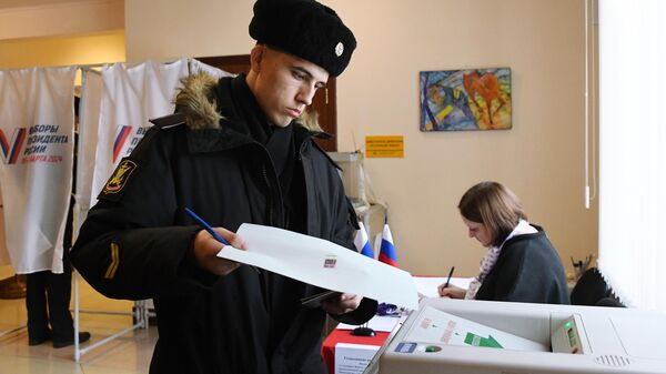 Военнослужащий Тихоокеанского флота голосует на выборах президента России на избирательном участке №502 во Владивостоке