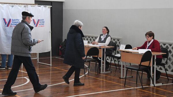 Люди регистрируются перед началом голосования на выборах президента России на избирательном участке №4124 во Владивостоке