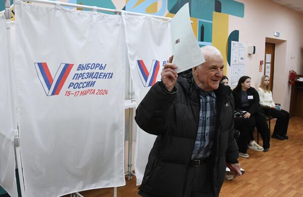 Мужчина голосует на выборах президента России на избирательном участке №4127 во Владивостоке