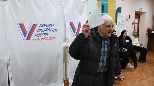 Мужчина голосует на выборах президента России на избирательном участке №4127 во Владивостоке