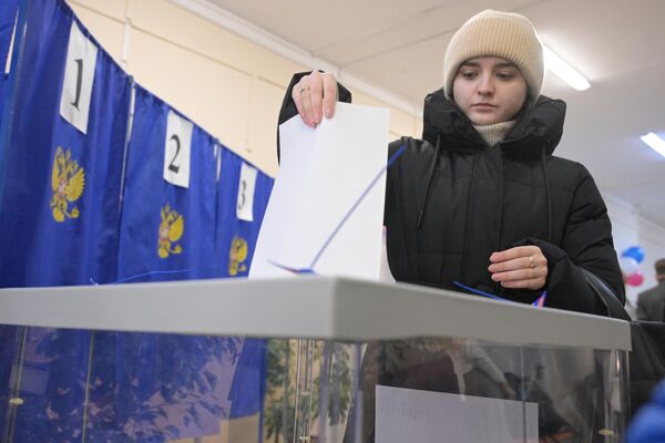 Девушка голосует на выборах президента России на одном из избирательных участков в Новосибирске