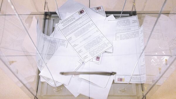 Бюллетени в урне для голосования на выборах президента России