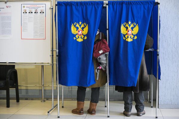 Люди голосуют на выборах президента России на избирательном участке в Доме ученых СО РАН в Академгородке в Новосибирске