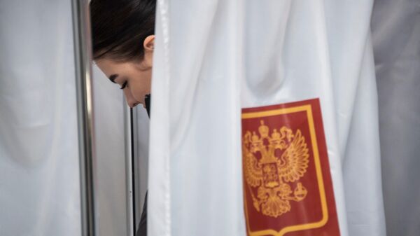 Женщина голосует на выборах президента РФ на избирательном участке