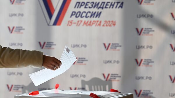 Женщина голосует на выборах президента России на избирательном участке