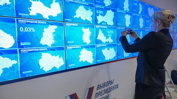 Экраны в Информационном центре Центральной избирательной комиссии РФ с данными о ходе голосования на выборах президента РФ