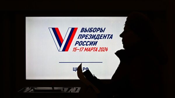 Женщина голосует на выборах президента России на избирательном участке в Луганске