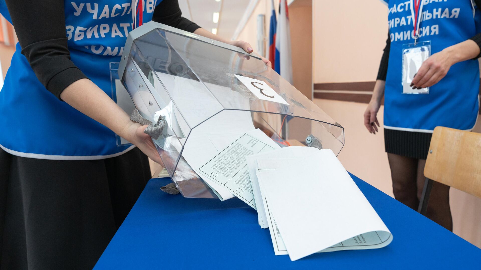 Члены участковой избирательной комиссии  достают бюллетени для голосования на выборах президента России - РИА Новости, 1920, 15.03.2024