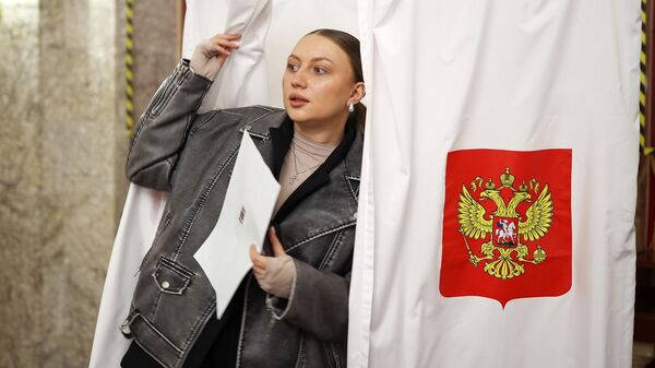 Девушка принимает участие в голосовании на выборах президента России