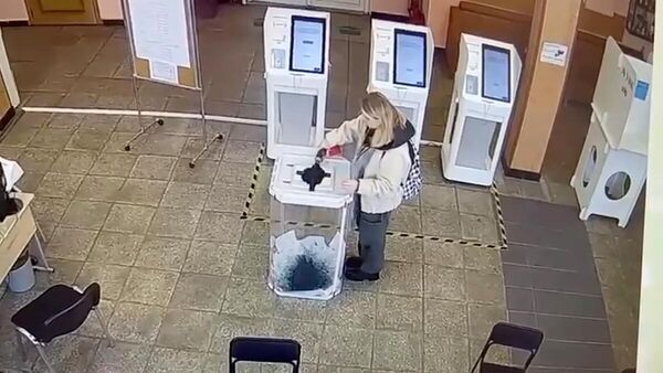 Кадр видео с избирательного участка в Москве, где девушка вылила красящее вещество в урну с бюллетенями
