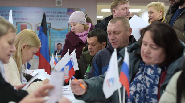 Люди голосуют на выборах президента России на избирательном участке в Кировское